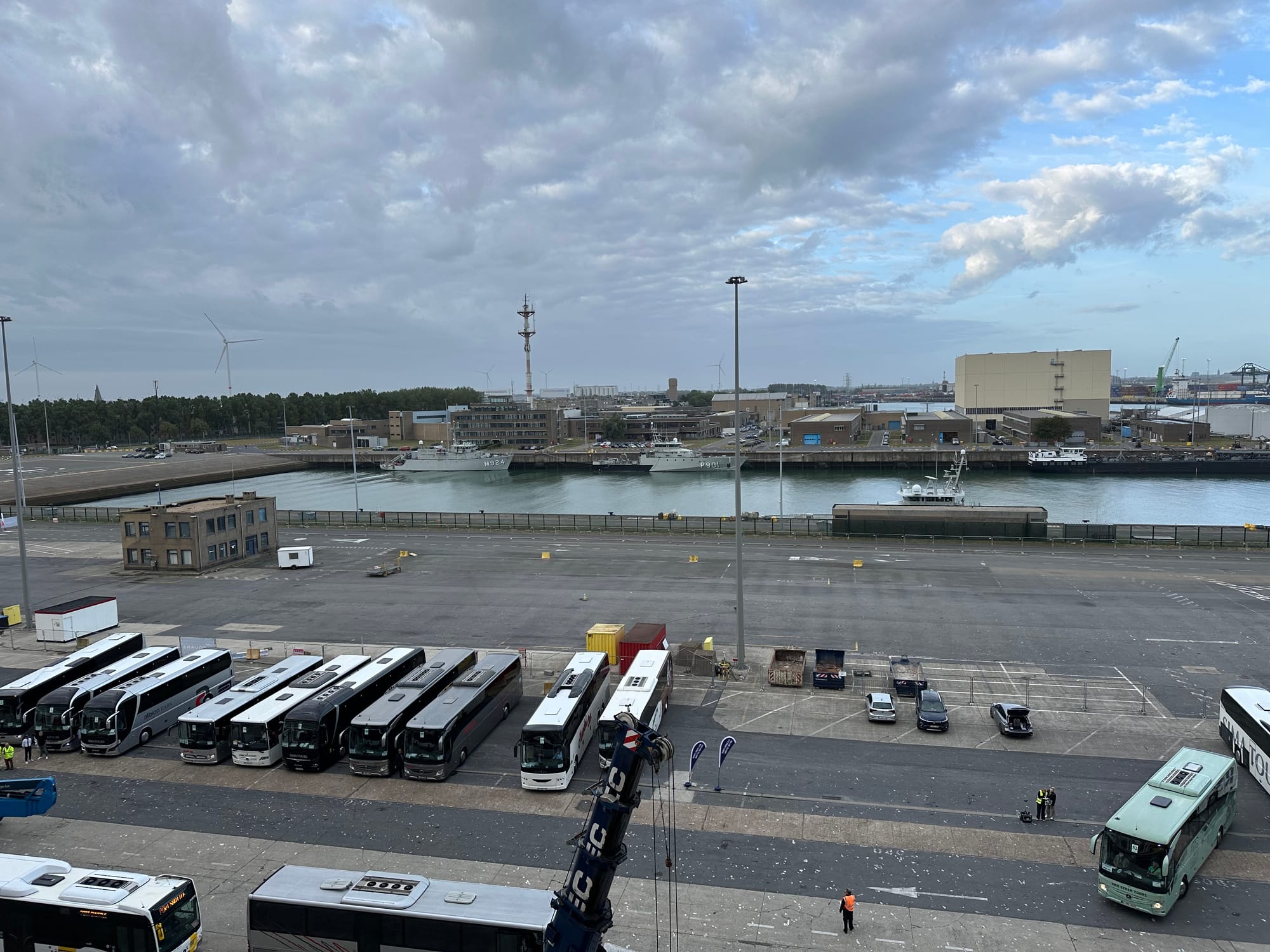 The image shows a view of the port at Zeebrugge and around 12 coaches lined up to take people either to the port entrance or to Blankenberge
