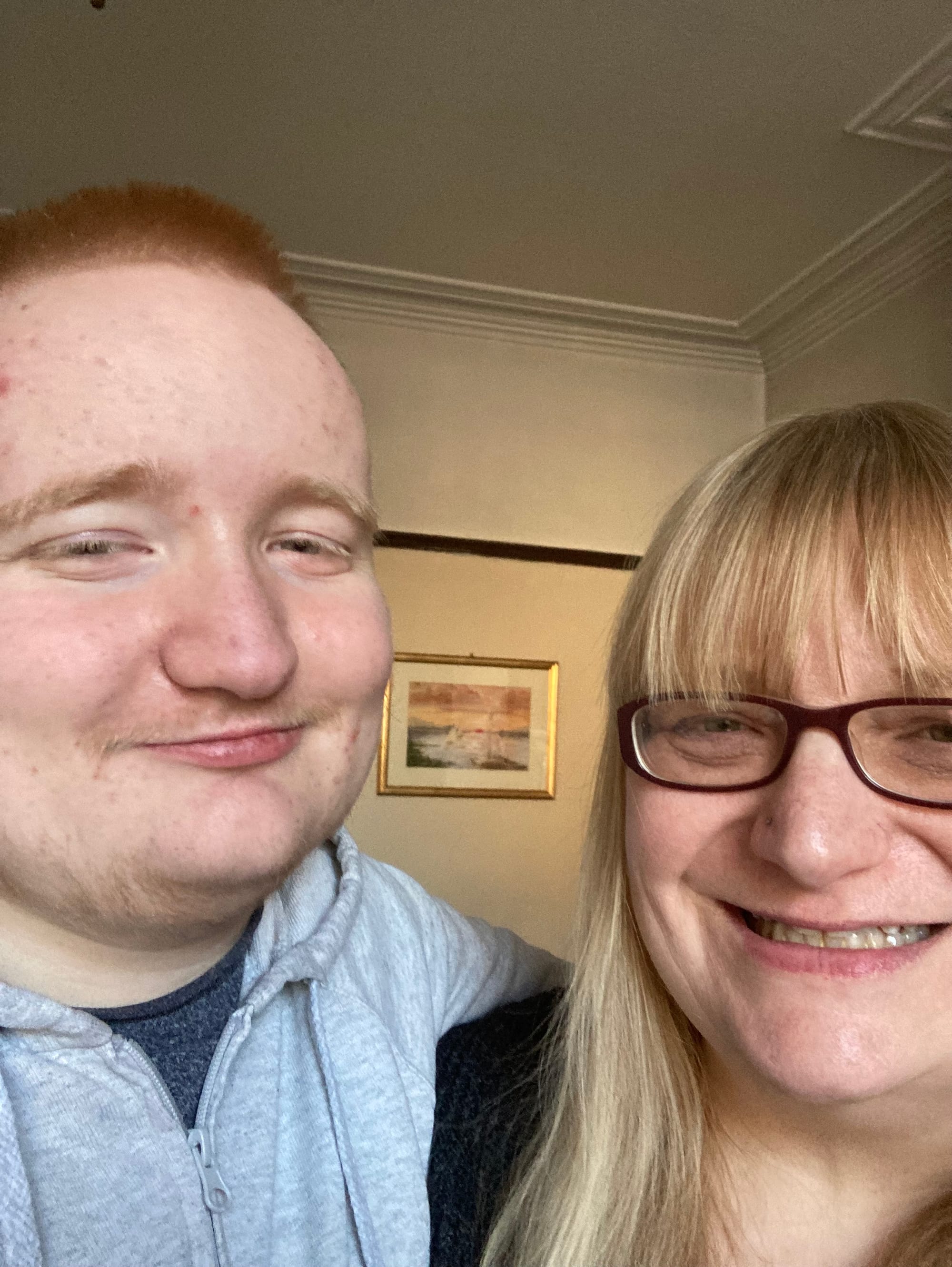 The image shows a tall young man with his arm around a slightly shorter woman. They are both smiling.
