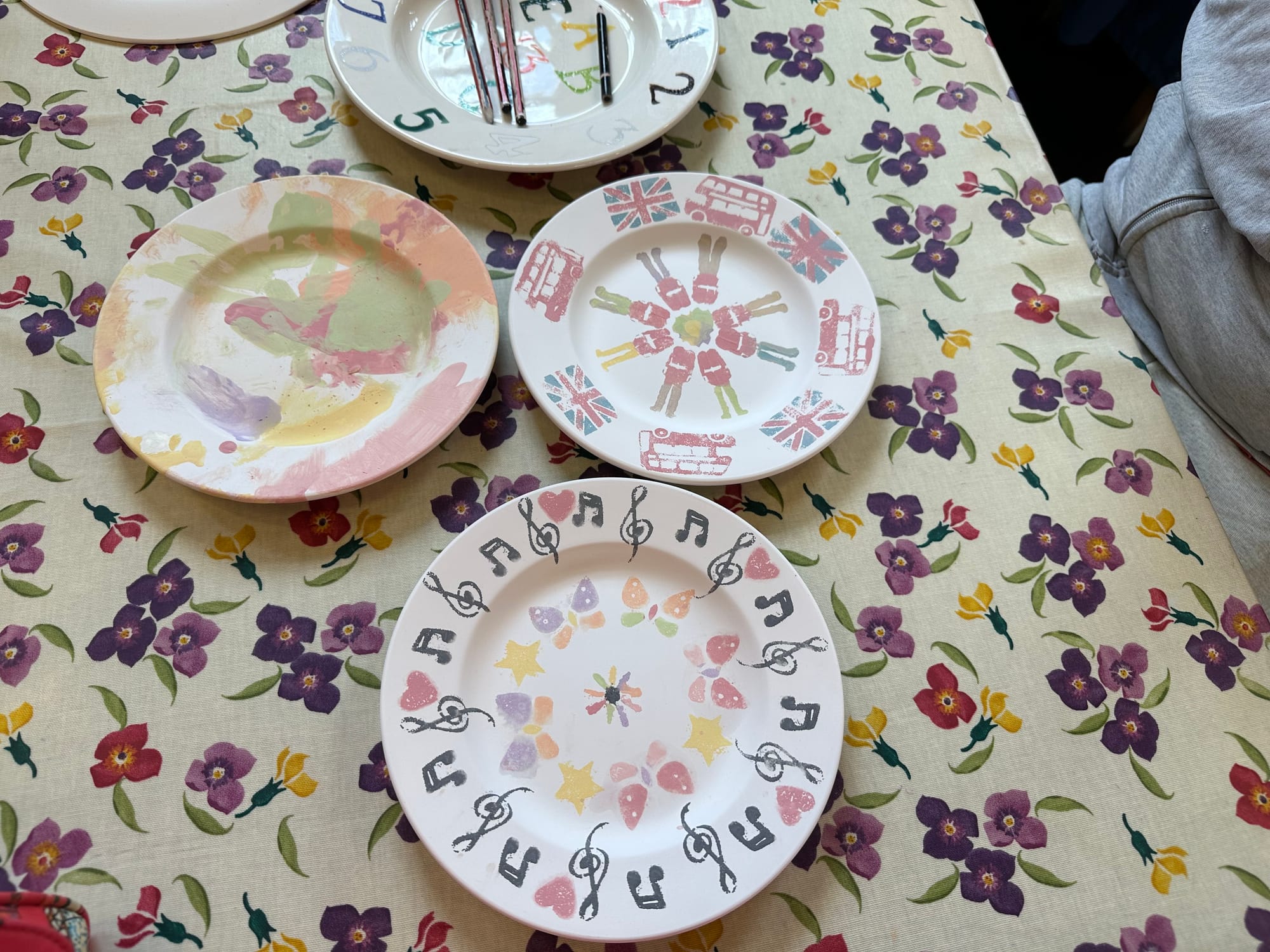 Three decorated plates on a floral table cloth