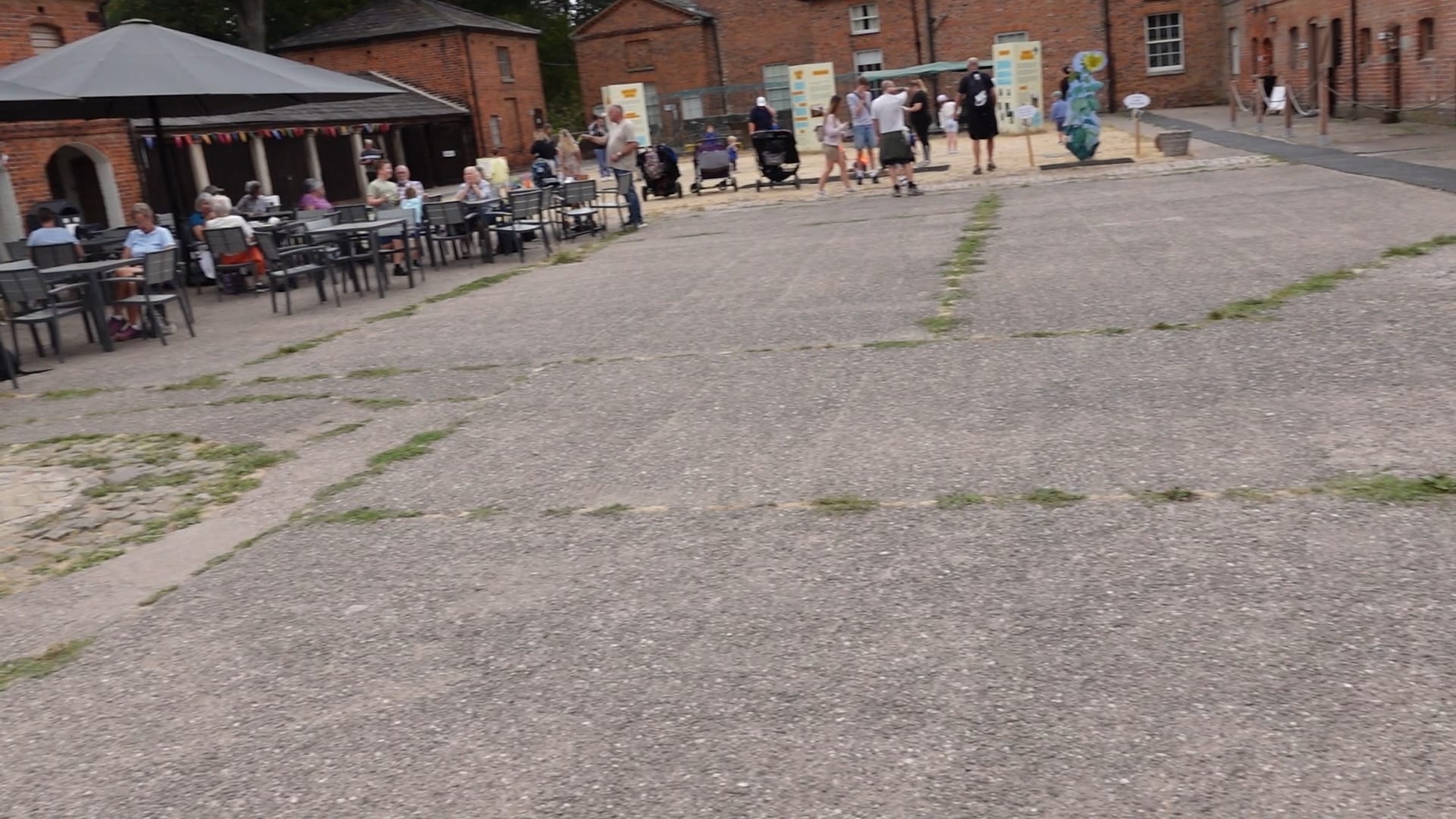 A view of the courtyard. A tearoom is on the left and some red brick buildings on the right