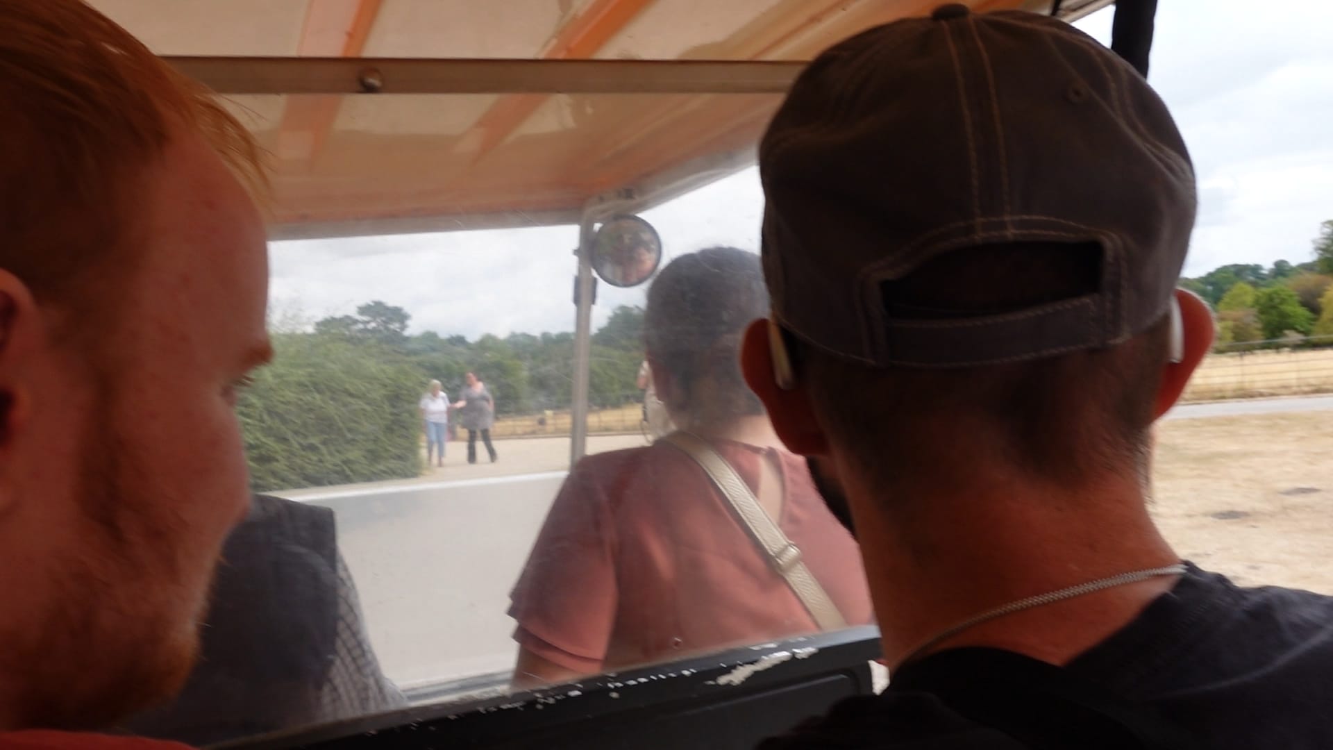 George is on the left looking slightly to his right, out of the shuttle. John is on the right and we see the back of his head, as he sits on the seat in front of the camera