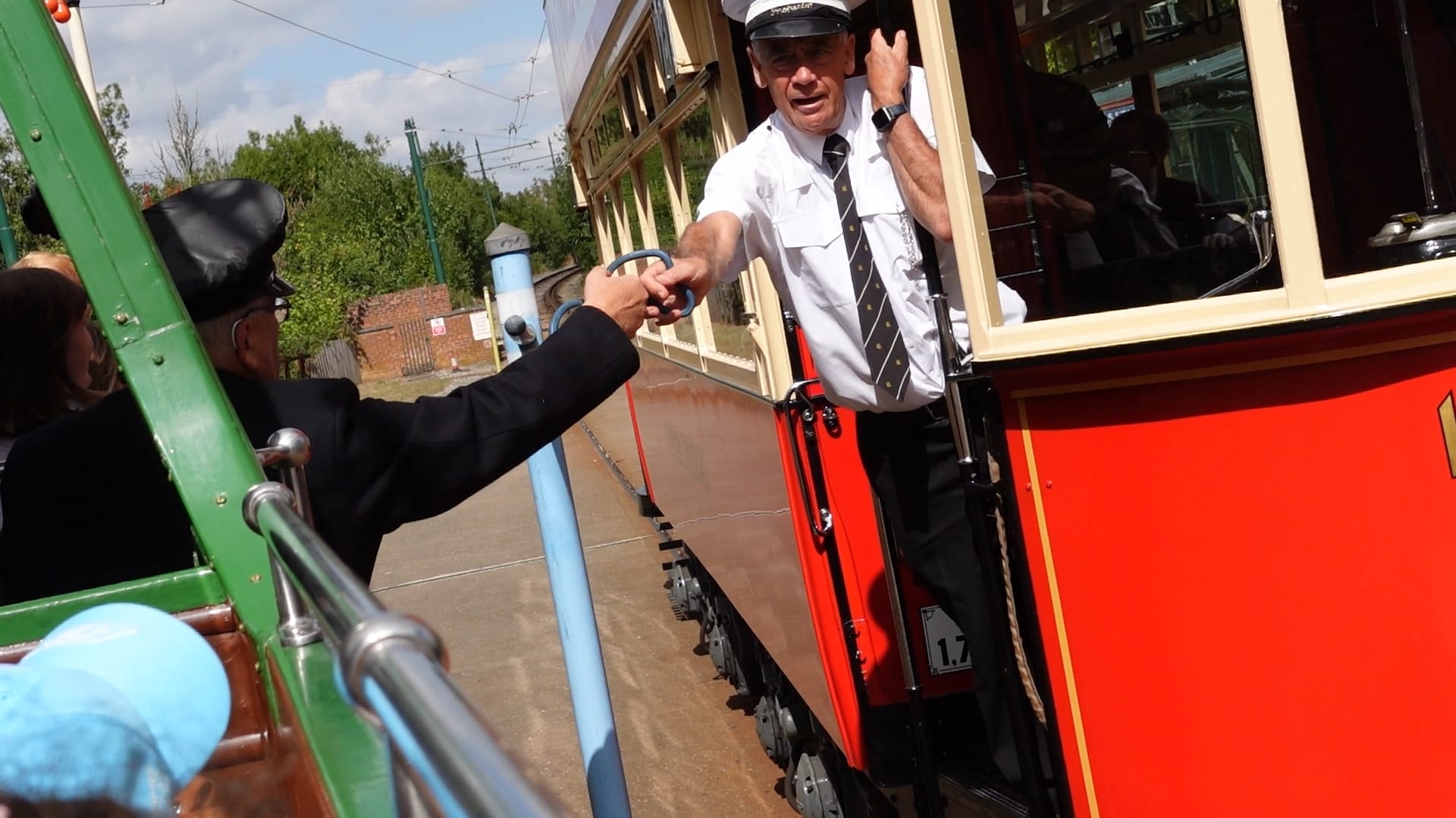 Our conductor has his right arm stretched out to hand the token over the the tram we were passing