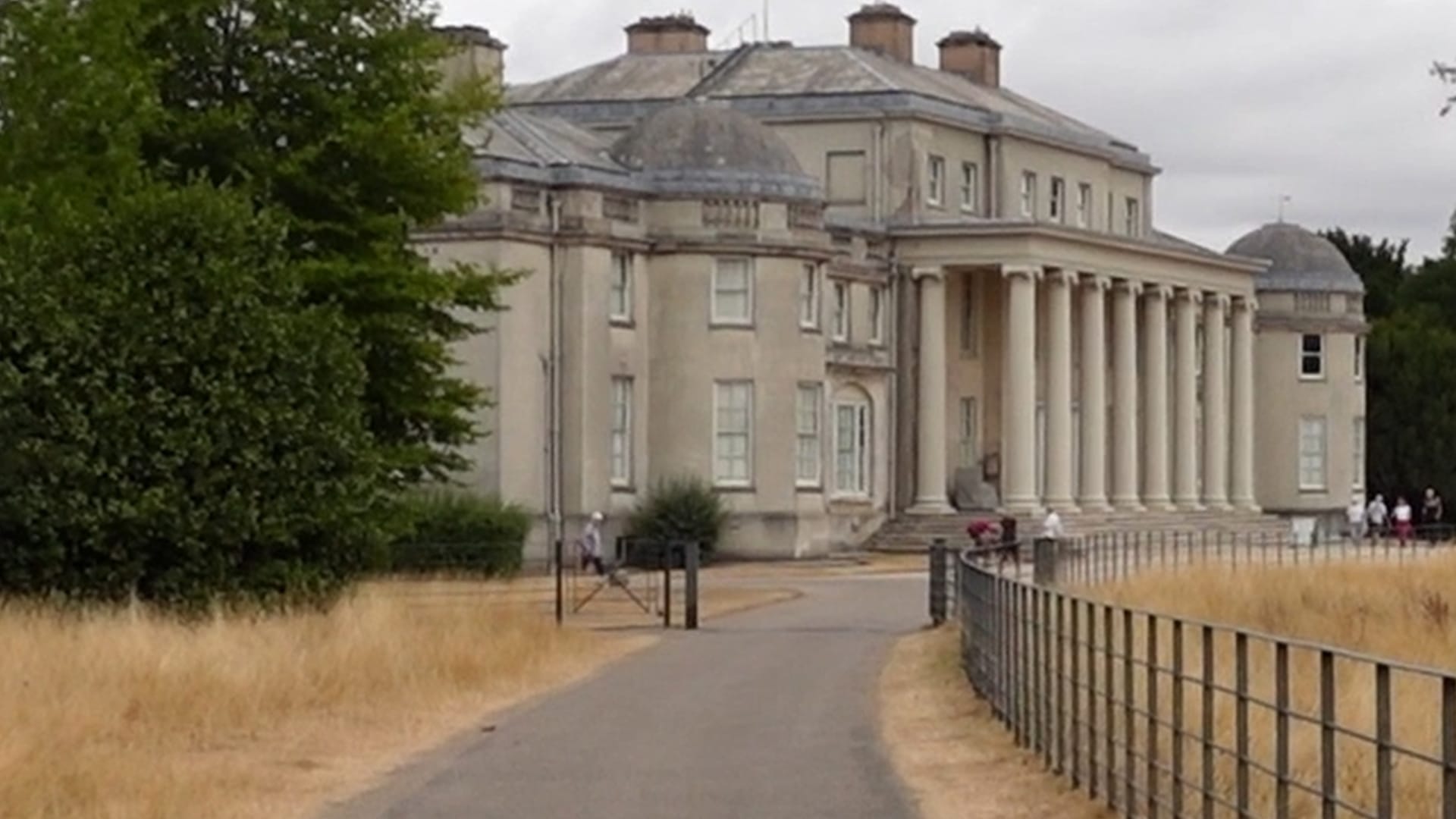 Nearing the end of the road. There is a cattle grid in front and a closer view of the mansion