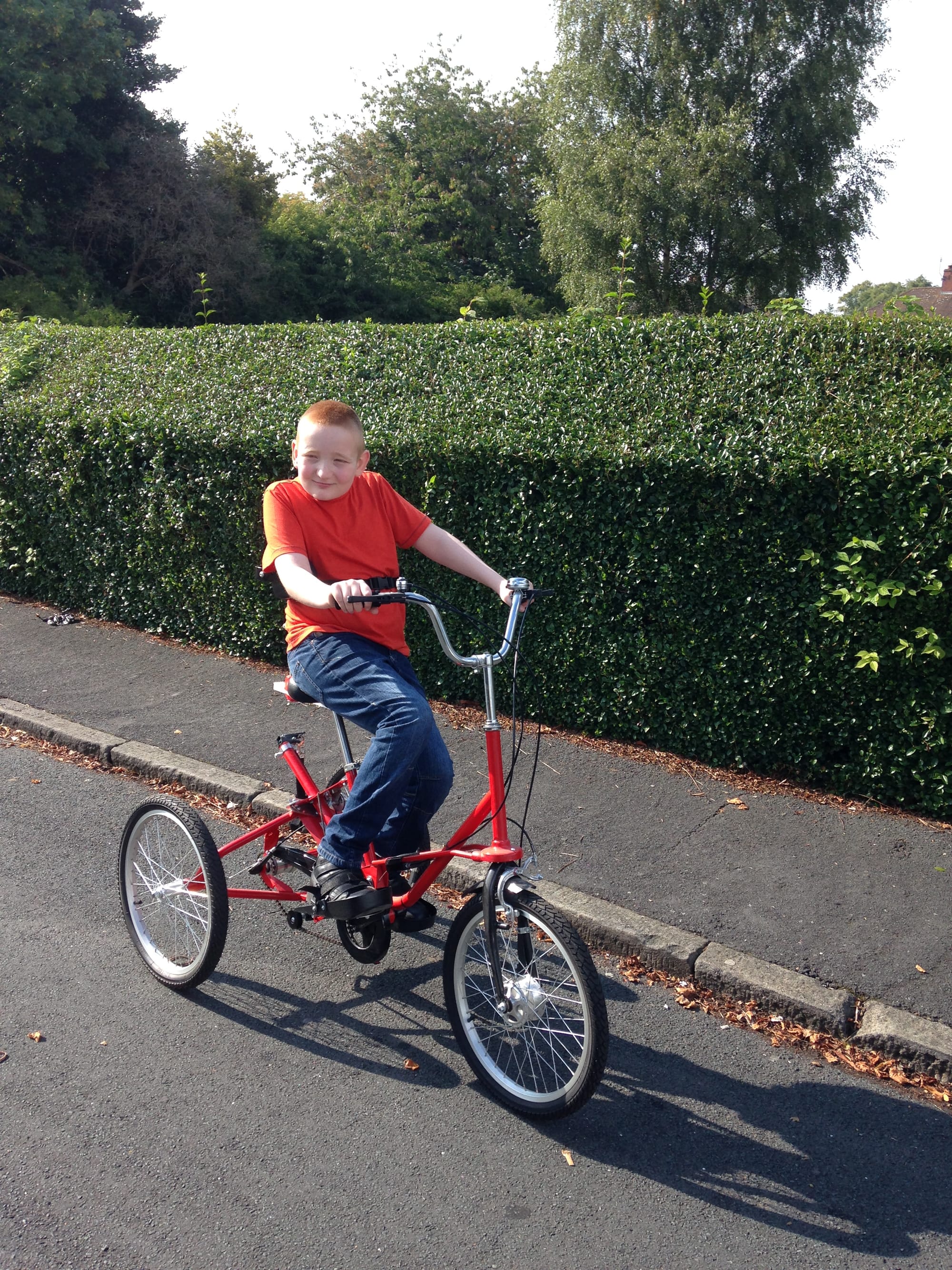 George, aged 11, on his red trike. 