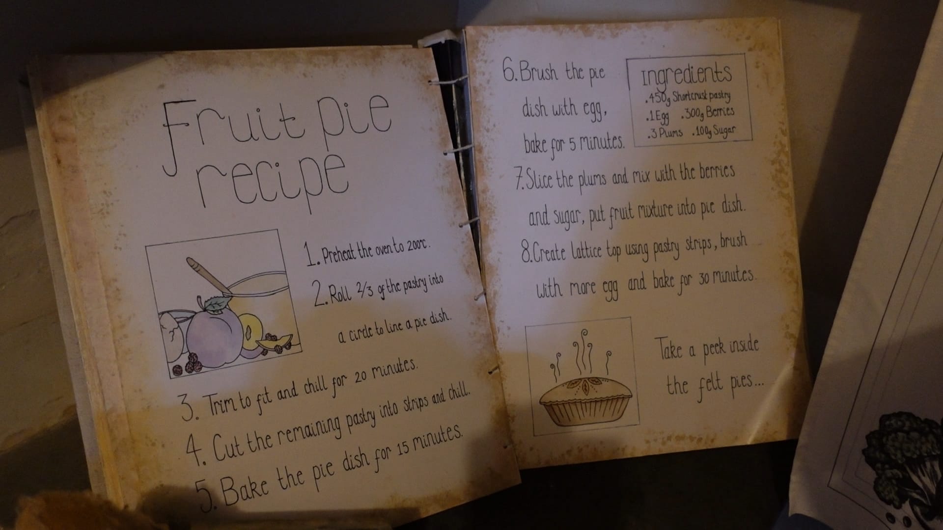 A large open book, open at a page showing the recipe for a fruit pie. The weights of the ingredients are in grams, so it is a modern take on an old recipe