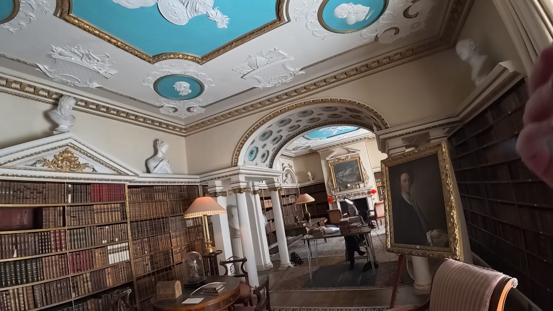 An ornate looking room, full of shelfs full of old books.