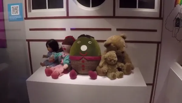 A display of vintage toys on a pedestal, including Hamble, Jemima, Humpty, and Big Ted and Little Ted, set against a playhouse backdrop. They were on the preschool TV programme Playschool.